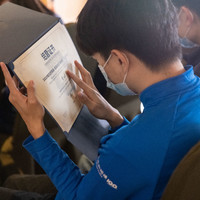 一位学员在用手读出证书上的盲文